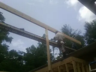 Carpenter setting a ridge beam over a new addition frame — Ice Dam Removal by Roofing Brothers in Killbuck