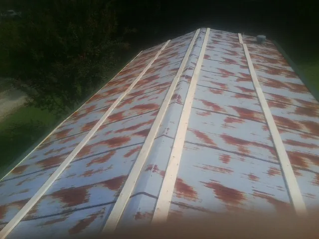 Rusted metal roof panels with new wood purlins before replacement — Storm Damage Roof Repair in Killbuck by Roofing Brothers