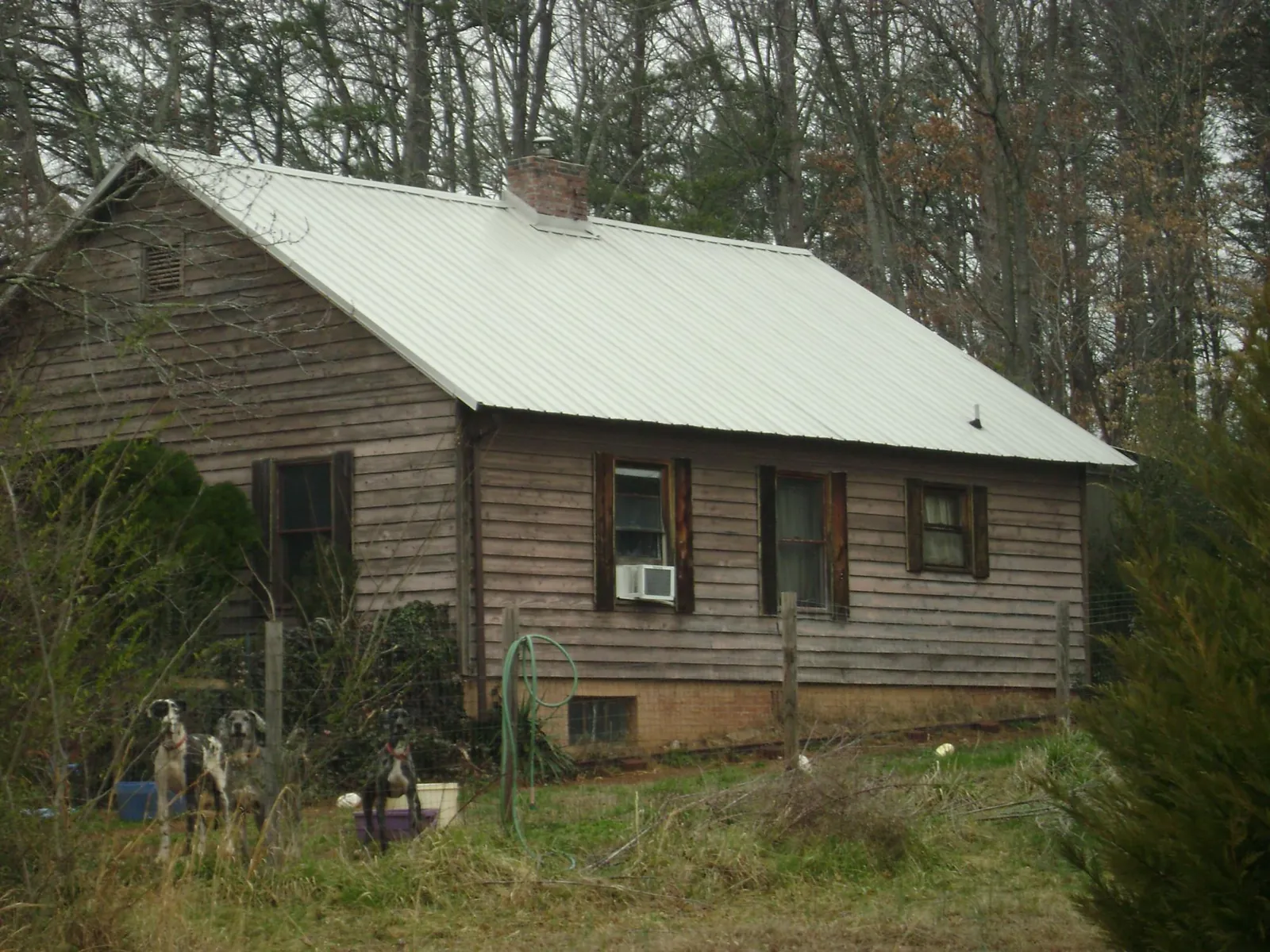 White metal roof on an old wood sided farmhouse, from a Metal Roof Installation job in Killbuck